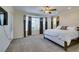 Spacious main bedroom featuring a large window, ceiling fan, and plush carpet at 10372 Premia Pl, Las Vegas, NV 89135
