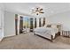 Bright main bedroom with a ceiling fan, bay windows, and neutral decor at 10372 Premia Pl, Las Vegas, NV 89135