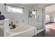 Bathroom featuring a separate tub with tiled surround and a glass enclosed shower at 10519 Bella Camrosa Dr, Las Vegas, NV 89141