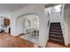 View of the dining room and stairs from the kitchen, showcasing archway and wood floors at 10519 Bella Camrosa Dr, Las Vegas, NV 89141