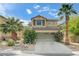 Charming two-story home featuring desert landscaping, a two-car garage, and mature palm trees at 10519 Bella Camrosa Dr, Las Vegas, NV 89141