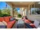 Back patio with outdoor seating and pillows for relaxing in the shade of a covered area overlooking the pool at 10519 Bella Camrosa Dr, Las Vegas, NV 89141