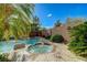 The backyard has a pool, spa, waterfall, and lush landscaping, offering the ultimate outdoor experience at 10519 Bella Camrosa Dr, Las Vegas, NV 89141