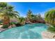 Relaxing backyard pool with tropical landscaping, rock waterfall, and hammock at 10519 Bella Camrosa Dr, Las Vegas, NV 89141