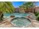 Backyard featuring a pool, spa, waterfall, mature landscaping, and a BBQ area, perfect for entertaining at 10519 Bella Camrosa Dr, Las Vegas, NV 89141