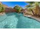 Beautiful backyard pool with stone waterfall feature and lush tropical landscaping at 10519 Bella Camrosa Dr, Las Vegas, NV 89141
