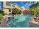 Inviting backyard pool and spa with mature palm trees and rock waterfall feature at 10519 Bella Camrosa Dr, Las Vegas, NV 89141