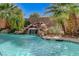 Beautiful pool waterfall surrounded by rock and landscaping for relaxing by the pool at 10519 Bella Camrosa Dr, Las Vegas, NV 89141