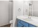 Bathroom with blue vanity, white countertops, toilet, and mirror at 1084 Little House Ct, Henderson, NV 89011