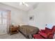 Comfortable bedroom with a twin bed, a window with curtains, and a red chair at 1084 Little House Ct, Henderson, NV 89011