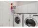 Well-organized laundry room featuring a washer, dryer, storage cabinets, and shelving at 1084 Little House Ct, Henderson, NV 89011