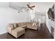Inviting living room featuring vaulted ceilings, a ceiling fan, a fireplace, and dark hardwood flooring at 1084 Little House Ct, Henderson, NV 89011