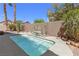 Sparkling backyard pool with waterfall feature, surrounded by lush greenery and desert plants at 1084 Little House Ct, Henderson, NV 89011