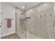 Bathroom showcasing a tiled glass shower, neutral colors, and bronze hardware at 10886 Porto Foxi St, Las Vegas, NV 89141