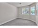 Bright bedroom with carpet, baseboards, and view from large windows at 10886 Porto Foxi St, Las Vegas, NV 89141