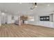 Open concept living room with wood flooring, island with seating, and ample natural light throughout at 10886 Porto Foxi St, Las Vegas, NV 89141