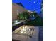 Inviting backyard with a fire pit, tasteful landscape, water feature, and stylish lighting at 10968 Tracy Stevens Ave, Las Vegas, NV 89166