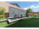 Serene backyard with a modern water feature and lush artificial turf and green plants at 10968 Tracy Stevens Ave, Las Vegas, NV 89166