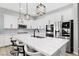 Well-lit kitchen with an island, white cabinets, modern appliances, and stylish black and white bar stools at 10968 Tracy Stevens Ave, Las Vegas, NV 89166