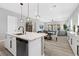 Open kitchen with a white marble island countertop, stylish pendant lighting and view to dining and living area at 10968 Tracy Stevens Ave, Las Vegas, NV 89166