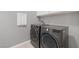 Modern laundry room featuring front loading gray washer and dryer and upper cabinets at 10968 Tracy Stevens Ave, Las Vegas, NV 89166