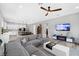 Spacious living room with an open layout, featuring a gray sectional, modern furniture, and a large TV at 10968 Tracy Stevens Ave, Las Vegas, NV 89166