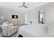 Spacious main bedroom featuring neutral walls, ceiling fan, tv, and two chairs at 10968 Tracy Stevens Ave, Las Vegas, NV 89166