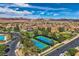 Aerial view showcasing neighborhood tennis courts, community amenities, and mountain views at 1113 Via Della Costrella, Henderson, NV 89011