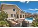 Resort-style backyard with a sparkling pool, spa, covered patio, and fire pit area at 1113 Via Della Costrella, Henderson, NV 89011