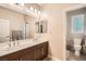 Bathroom featuring double sinks, a large mirror and a separate toilet room at 1113 Via Della Costrella, Henderson, NV 89011