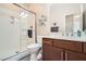 Bathroom with modern shower, vanity with a white sink and wood cabinets at 1113 Via Della Costrella, Henderson, NV 89011