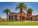 Beautiful clubhouse exterior with stone accents, arched entrance, and mature palm trees at 1113 Via Della Costrella, Henderson, NV 89011