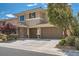 Inviting exterior view of a two-story home with a two-car garage, accented by lush landscaping and stone details at 1113 Via Della Costrella, Henderson, NV 89011
