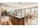 Open floor plan featuring a kitchen island with sink, dining area, and living room at 1113 Via Della Costrella, Henderson, NV 89011