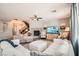 Bright, spacious living room with a fireplace, soft furniture, ceiling fan, and staircase for multi-level living at 1113 Via Della Costrella, Henderson, NV 89011