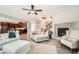 Spacious living room open to kitchen with a fireplace, light furniture, ceiling fan, and modern flooring at 1113 Via Della Costrella, Henderson, NV 89011