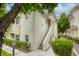 View of a two-story condo building with an exterior staircase, small green bushes and a streetlight at 1420 Red Crest Ln # 202, Las Vegas, NV 89144