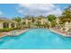 Resort-style community pool with plenty of lounge chairs surrounded by landscaping and trees at 1420 Red Crest Ln # 202, Las Vegas, NV 89144