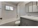 Cozy bathroom with white tiled shower-tub, gray vanity, and large, mirrored cabinet at 155 Magnesium St, Henderson, NV 89015