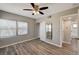 Bedroom featuring wood-look floors, a ceiling fan, and entry to an ensuite bathroom at 155 Magnesium St, Henderson, NV 89015