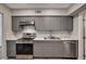 Updated kitchen featuring gray cabinets, quartz countertops, and stainless-steel appliances at 155 Magnesium St, Henderson, NV 89015