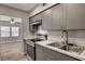 Updated kitchen features stainless steel appliances and gray cabinets, with wood-look floors at 155 Magnesium St, Henderson, NV 89015