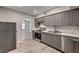 Modern kitchen featuring gray cabinets, stainless steel appliances, and wood-look flooring at 155 Magnesium St, Henderson, NV 89015