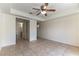 Spacious bedroom with a ceiling fan, neutral tile flooring, and access to a bathroom and closet at 1570 Jamielinn Ln # 104, Las Vegas, NV 89110