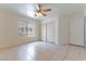 Bedroom with a ceiling fan, sliding closet doors, tile floors, and a bright window at 1570 Jamielinn Ln # 104, Las Vegas, NV 89110