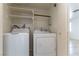 Cozy laundry room featuring a washer, dryer, and convenient shelving for storage at 1570 Jamielinn Ln # 104, Las Vegas, NV 89110