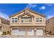 Beige two-story home with three-car garage and well-maintained landscaping at 1612 Lefty Garcia Way, Henderson, NV 89002