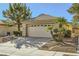 Well-maintained single-story house featuring a two-car garage, palm trees, and desert landscaping at 2105 Poppywood Ave, Henderson, NV 89012