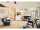 Inviting living room featuring neutral carpet, ceiling fan, and comfortable leather seating at 2105 Poppywood Ave, Henderson, NV 89012