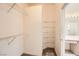 Walk-in closet with metal shelving and access to bathroom featuring vanity, sink, and mirrors at 2105 Poppywood Ave, Henderson, NV 89012